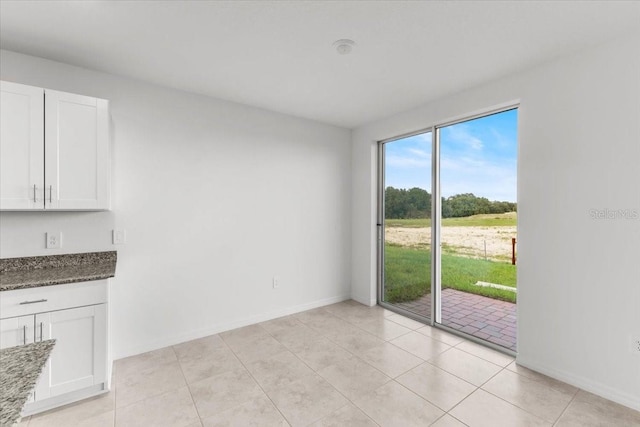 unfurnished dining area featuring light tile patterned floors