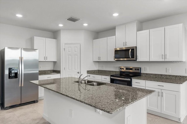 kitchen featuring appliances with stainless steel finishes, white cabinetry, a kitchen island with sink, and sink