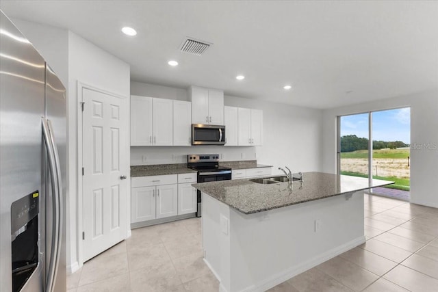 kitchen with appliances with stainless steel finishes, a kitchen island with sink, and white cabinets