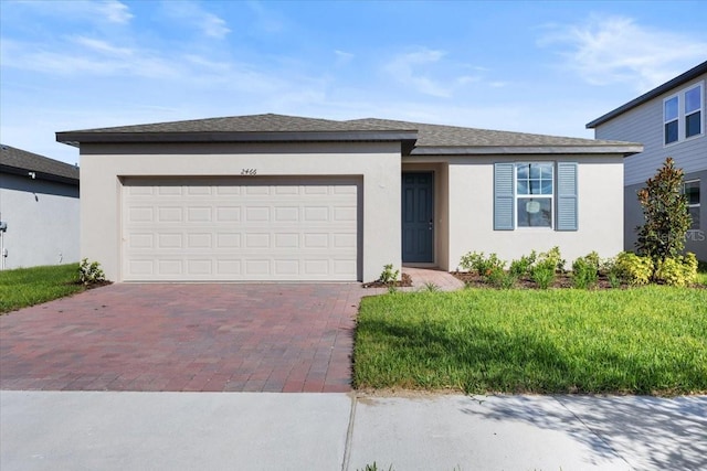 2466 Leeds St, Haines City, FL 33844 - view of front of property with stucco siding, a shingled roof, a garage, and decorative driveway