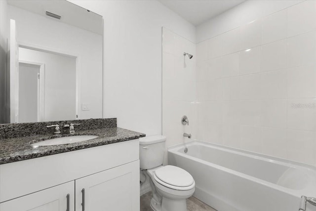 full bathroom featuring vanity, tiled shower / bath combo, and toilet