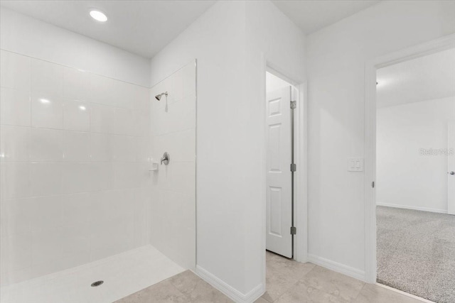 bathroom featuring a tile shower and tile patterned flooring