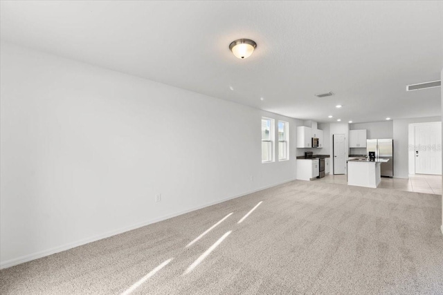 unfurnished living room featuring light carpet