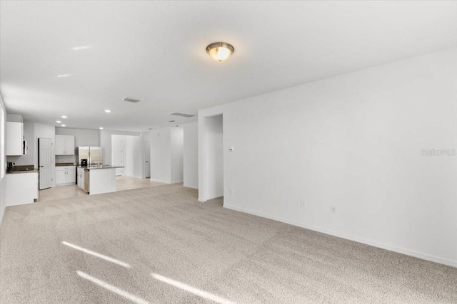 unfurnished living room with light carpet