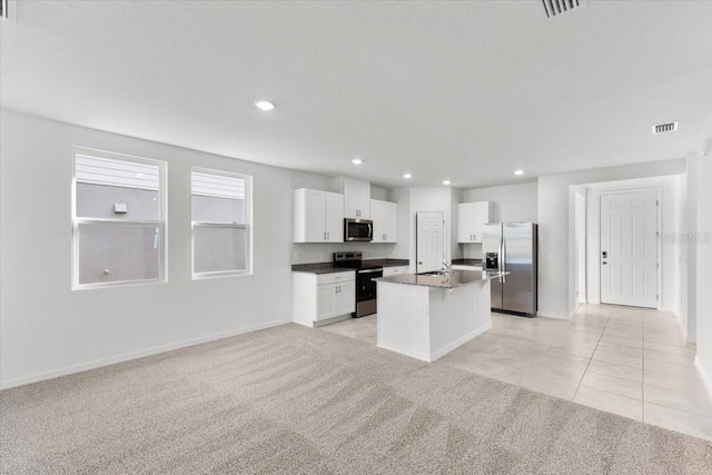 kitchen featuring appliances with stainless steel finishes, sink, a center island, white cabinets, and light colored carpet