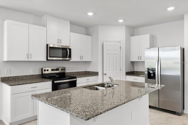 kitchen with appliances with stainless steel finishes, white cabinetry, a kitchen island with sink, and sink