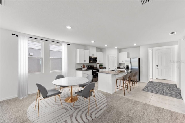 carpeted dining space with sink