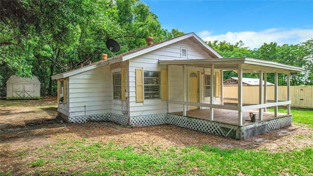 view of front of property with a shed and a wooden deck