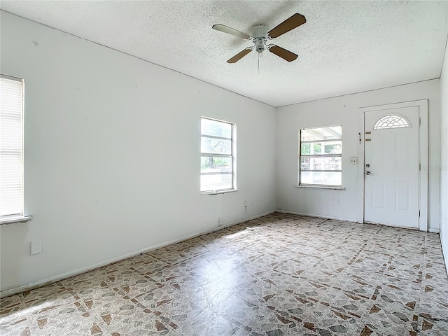 tiled foyer featuring ceiling fan and a textured ceiling