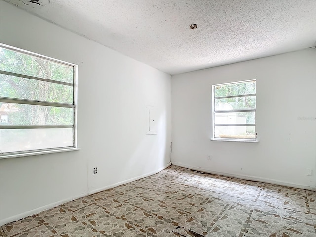 tiled spare room featuring a textured ceiling