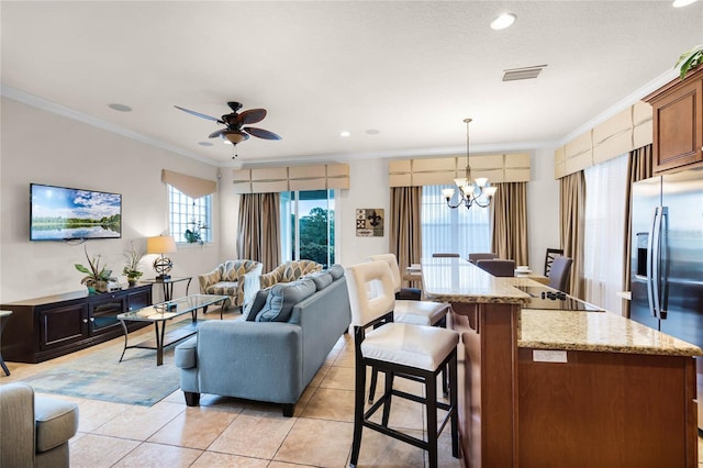 living room featuring ceiling fan with notable chandelier, light tile flooring, and ornamental molding