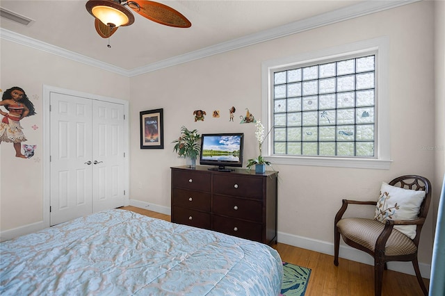 bedroom featuring ceiling fan, multiple windows, light wood-type flooring, and ornamental molding