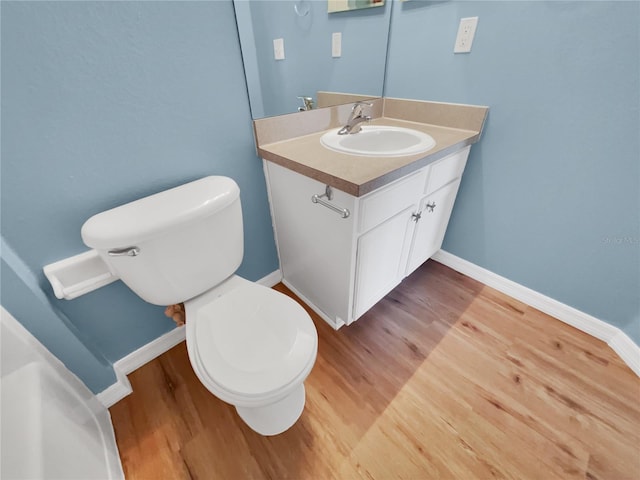 205 Hibiscus St, Winter Haven, FL 33881 - half bathroom with wood finished floors, vanity, toilet, and baseboards