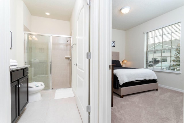 bathroom with tile flooring, vanity, toilet, and a shower with door