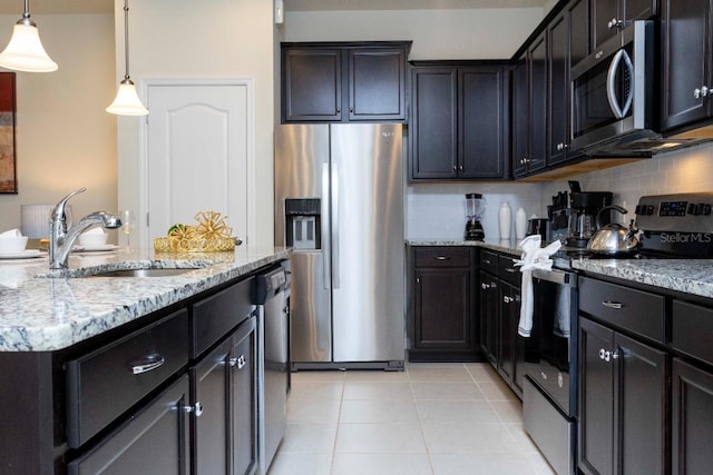 kitchen featuring stainless steel appliances, backsplash, hanging light fixtures, sink, and light tile floors