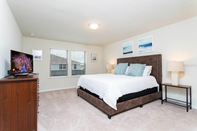 bedroom featuring a textured ceiling and light carpet