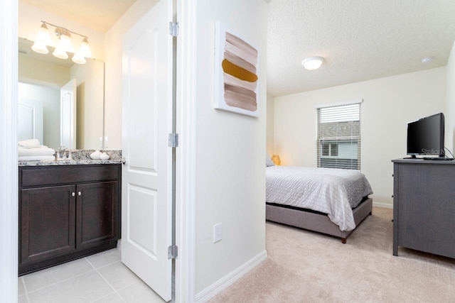 bedroom featuring sink, a textured ceiling, and light colored carpet