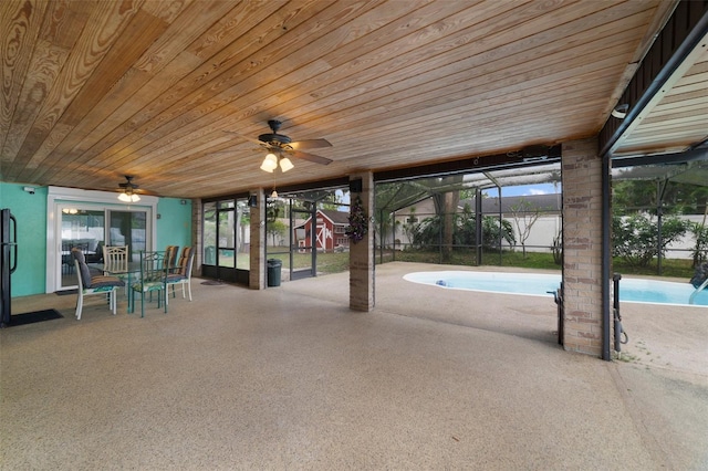 view of patio with ceiling fan and glass enclosure