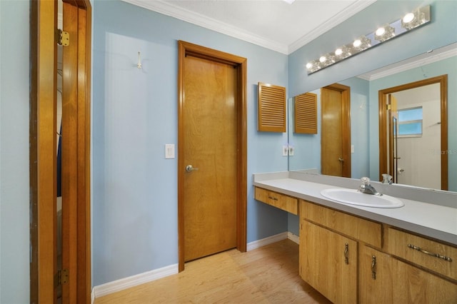 bathroom featuring ornamental molding, hardwood / wood-style flooring, and vanity