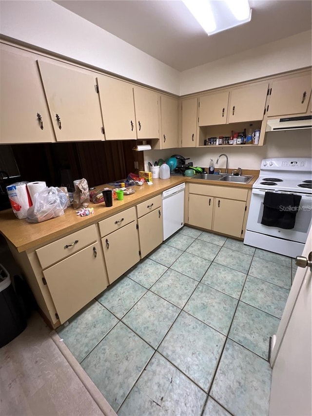 kitchen with white appliances, sink, light tile flooring, and cream cabinetry