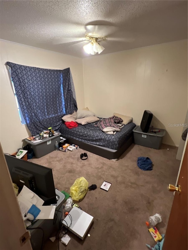 unfurnished bedroom featuring a textured ceiling, carpet floors, and a ceiling fan