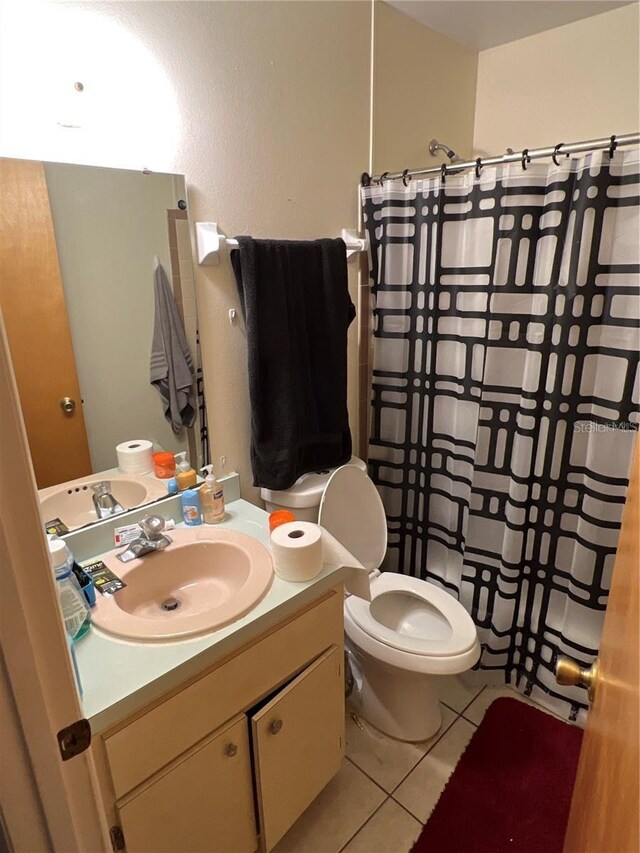 bathroom with a shower with shower curtain, vanity, toilet, and tile patterned floors