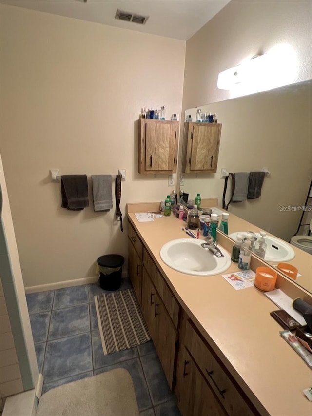 bathroom featuring baseboards, visible vents, and vanity