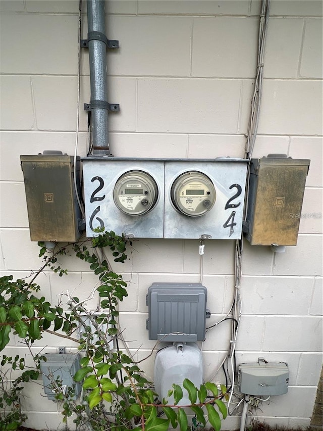 exterior details featuring electric meter and concrete block siding