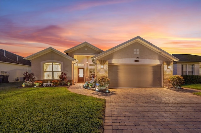 ranch-style home featuring a garage and a yard