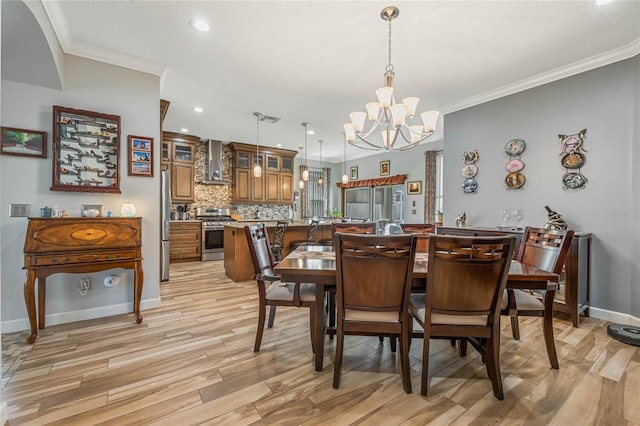 dining room featuring an inviting chandelier, ornamental molding, and light wood-type flooring