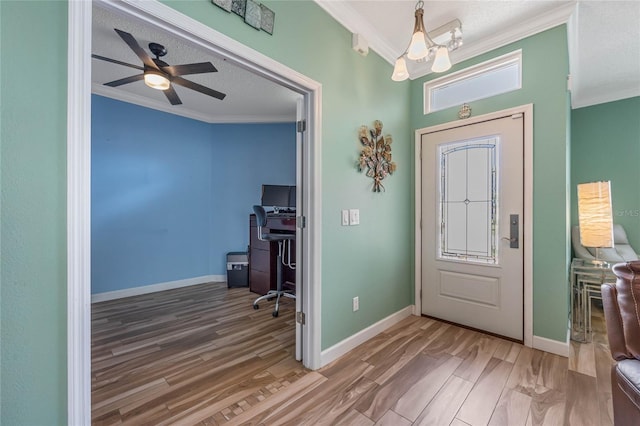 entryway featuring ornamental molding, ceiling fan with notable chandelier, a textured ceiling, and hardwood / wood-style flooring