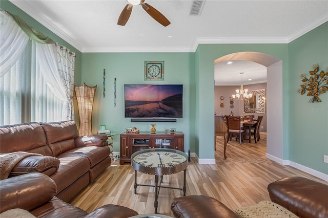 living room featuring hardwood / wood-style floors, ceiling fan with notable chandelier, and crown molding