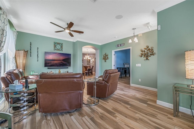 living room featuring crown molding, wood-type flooring, and ceiling fan with notable chandelier