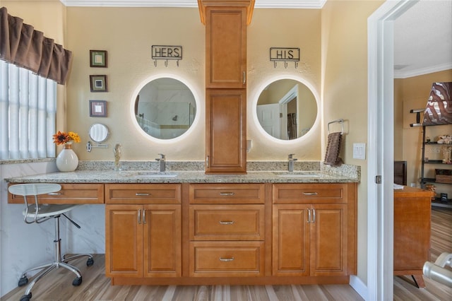 bathroom featuring dual vanity, ornamental molding, and wood-type flooring