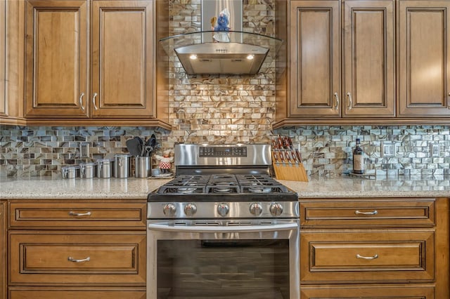 kitchen featuring gas stove, light stone countertops, wall chimney range hood, and tasteful backsplash