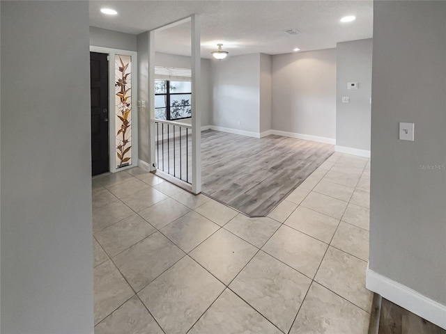 spare room featuring a textured ceiling and light wood-type flooring