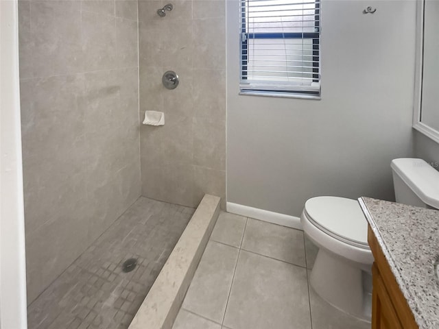 bathroom with tile patterned floors, vanity, a tile shower, and toilet