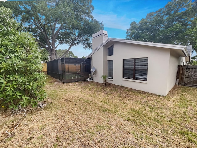 rear view of house with a sunroom and a lawn