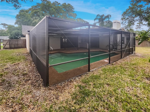 rear view of house with a fenced in pool and glass enclosure