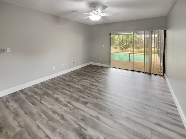 spare room with a textured ceiling, light wood-type flooring, and ceiling fan