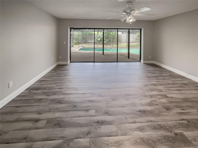 unfurnished room with hardwood / wood-style floors, ceiling fan, and a textured ceiling