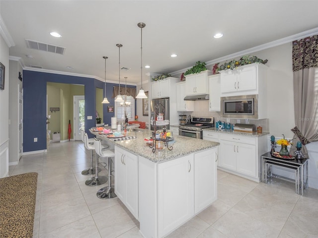 kitchen with stainless steel appliances, under cabinet range hood, ornamental molding, backsplash, and visible vents