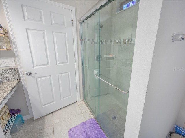 full bathroom featuring a shower stall, tile patterned floors, and baseboards