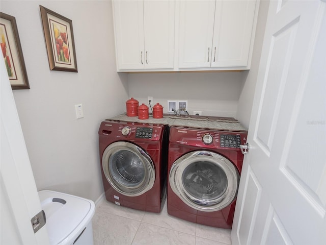 washroom featuring light tile patterned floors, washer and dryer, cabinet space, and baseboards
