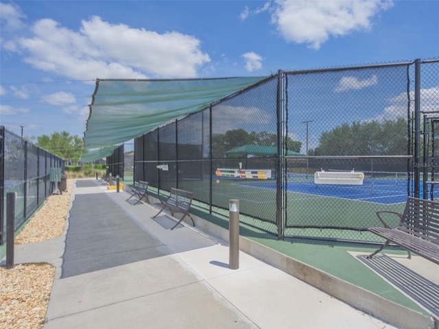view of tennis court featuring fence