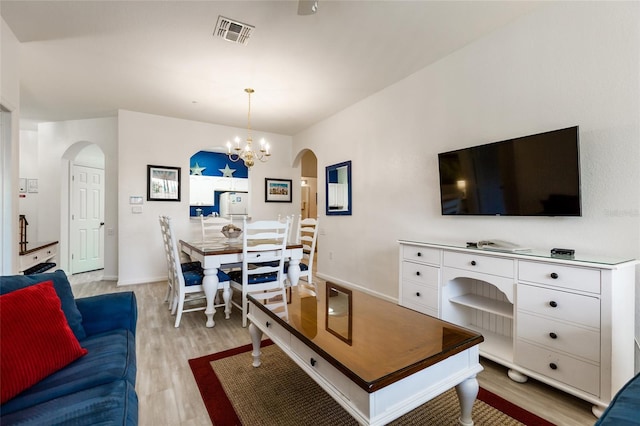 living room featuring light hardwood / wood-style floors and a notable chandelier