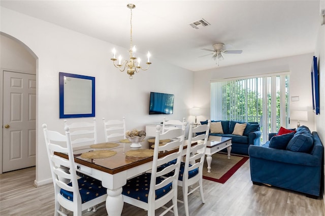 dining area featuring light hardwood / wood-style flooring and ceiling fan with notable chandelier