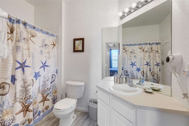 bathroom with oversized vanity, toilet, and hardwood / wood-style floors