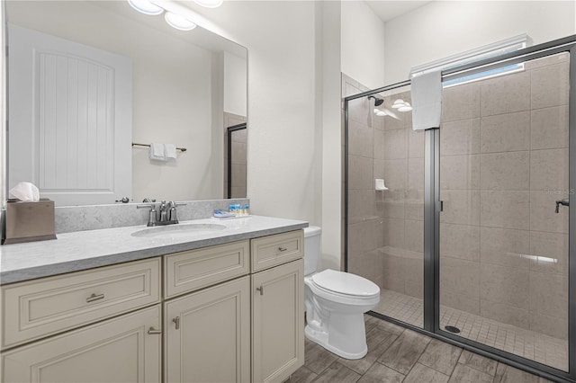 bathroom with vanity, toilet, and an enclosed shower