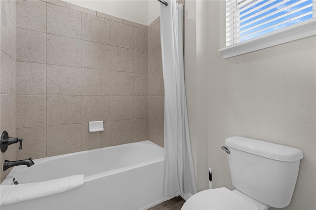 bathroom with shower / bath combination with curtain and toilet